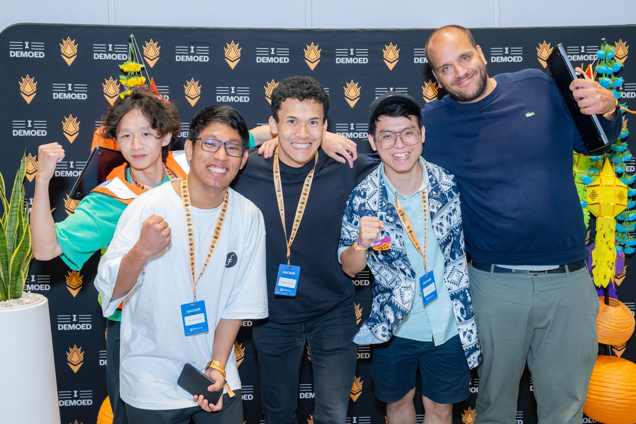 ETHGlobal BangkokのI DEMOEDの壁の前での集合写真